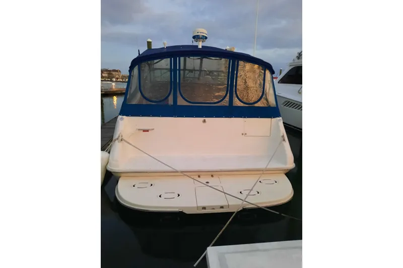 Slide: The Image of 1990 Sea Ray Sundancer 370 docked, featuring blue canopy and spacious swim platform. - 3