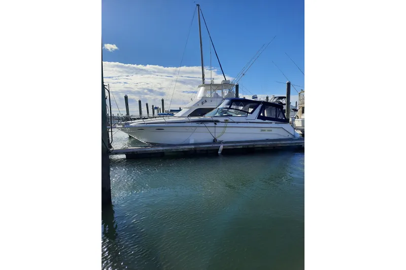 Slide: The Image of 1990 Sea Ray Sundancer 370 docked at marina under clear blue sky. - 4