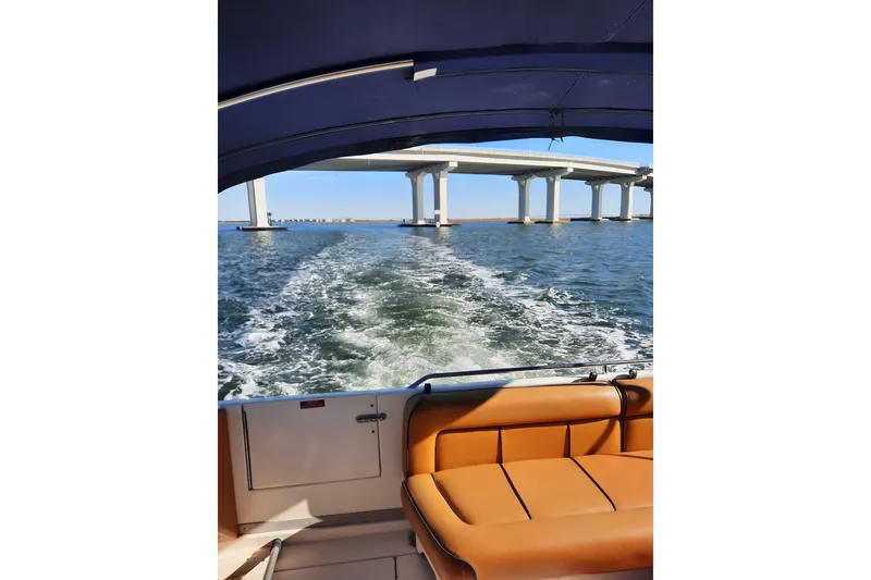 Slide: The Image of 1990 Sea Ray Sundancer 370 cruising under a bridge on open water. - 5