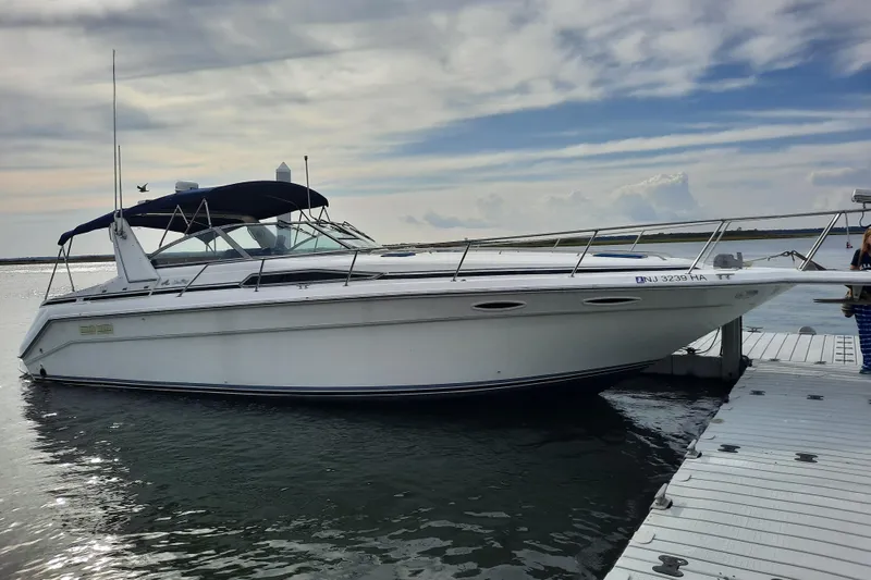 Slide: The Image of 1990 Sea Ray Sundancer 370 docked on a calm waterway under a cloudy sky. - 7