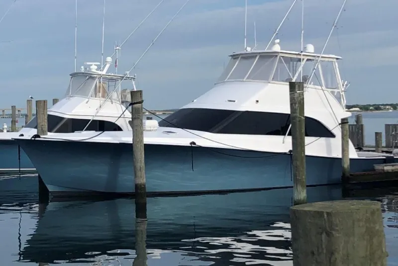 Slide: The Image of 1998 Ocean 53 Convertible yacht docked at marina, featuring sleek design and blue hull. - 1