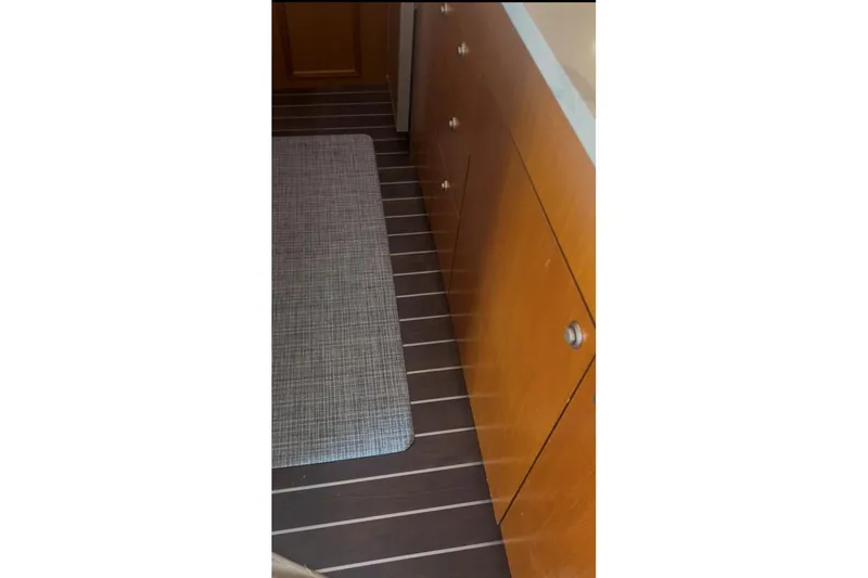 Slide: The Image of Interior of 1998 Ocean 53 Convertible yacht with wooden cabinetry and striped flooring. - 17