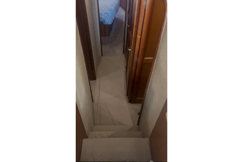 Slide: The Image of Interior hallway of a 1998 Ocean 53 Convertible yacht, featuring wooden doors and carpeted flooring. - 19
