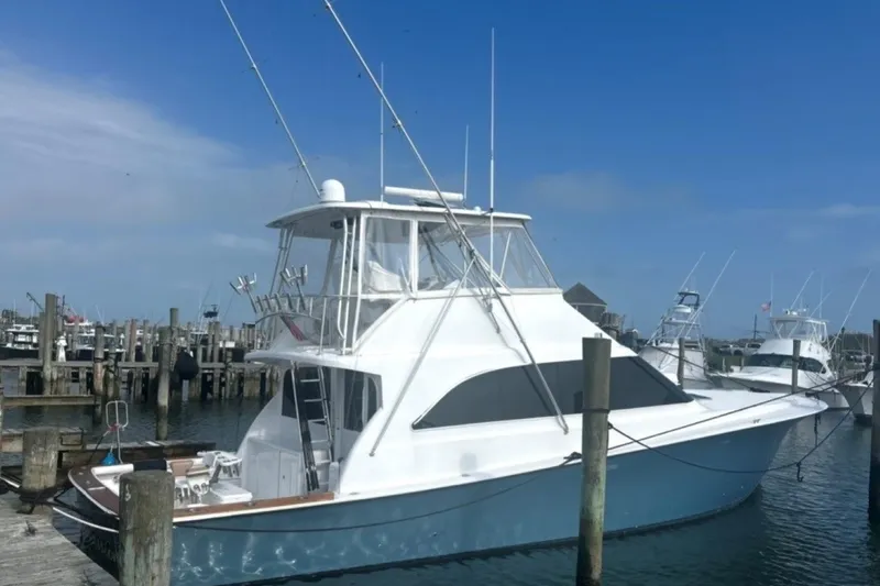 Slide: The Image of 1998 Ocean 53 Convertible yacht docked at a marina under a clear blue sky. - 2