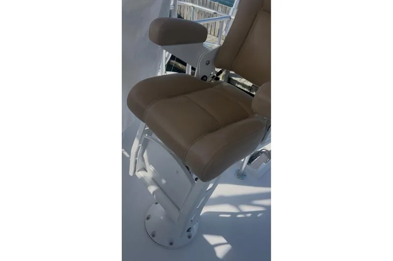 Slide: The Image of Captain's chair on 1998 Ocean 53 Convertible yacht, featuring tan upholstery and sturdy metal base. - 21