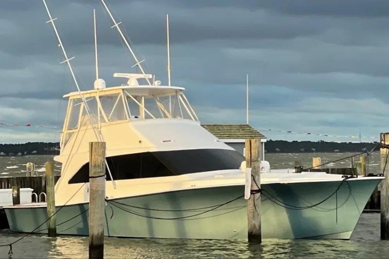 Slide: The Image of 1998 Ocean 53 Convertible yacht docked at a marina under cloudy skies. - 3