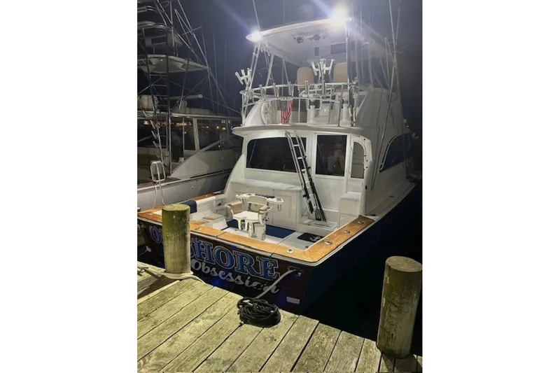 Slide: The Image of 1998 Ocean 53 Convertible yacht docked at night, illuminated with bright lights. - 7
