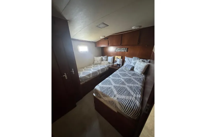 Slide: The Image of Cozy cabin interior of 1990 Hatteras 52 Convertible yacht with twin beds and nautical decor. - 14
