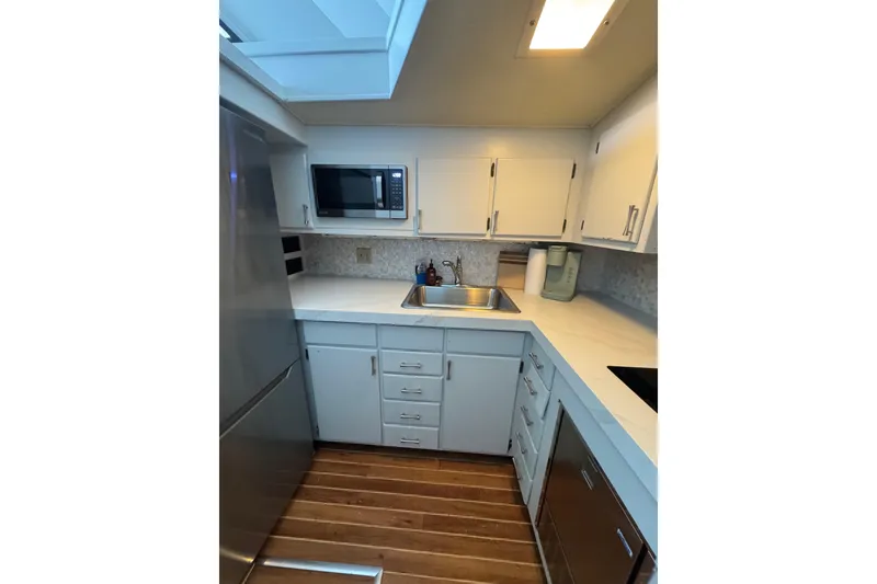 Slide: The Image of Compact kitchen in a 1990 Hatteras 52 Convertible yacht with modern appliances. - 15