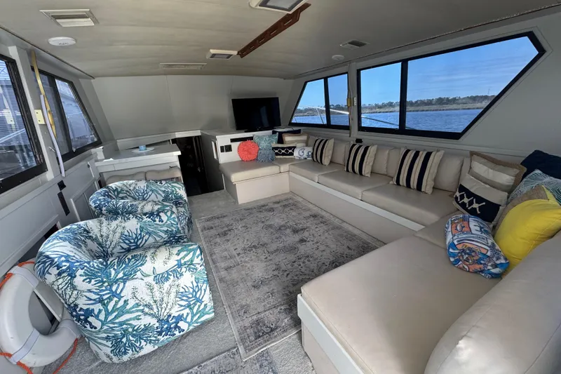 Slide: The Image of Luxurious interior of 1990 Hatteras 52 Convertible yacht with plush seating and scenic windows. - 16