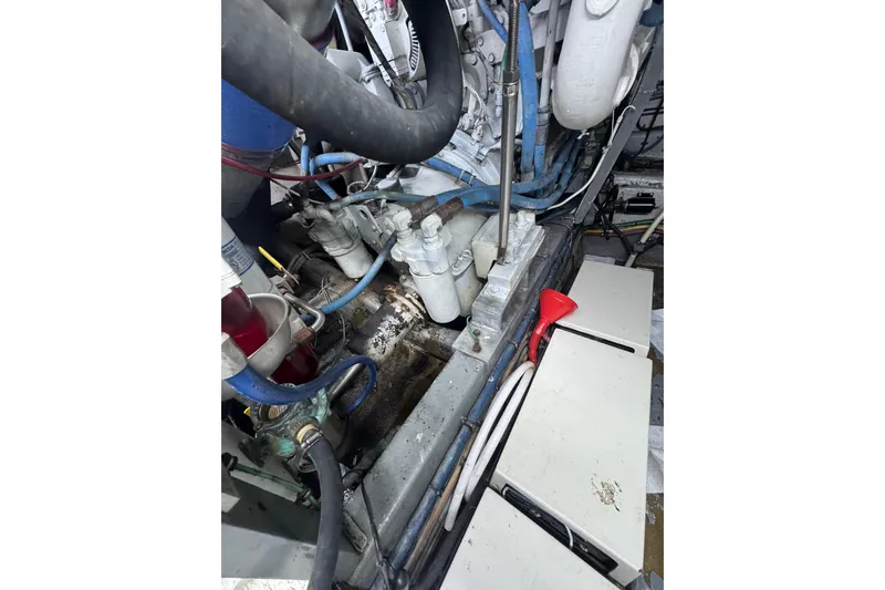 Slide: The Image of Engine compartment of a 1990 Hatteras 52 Convertible boat, showing hoses and components. - 24