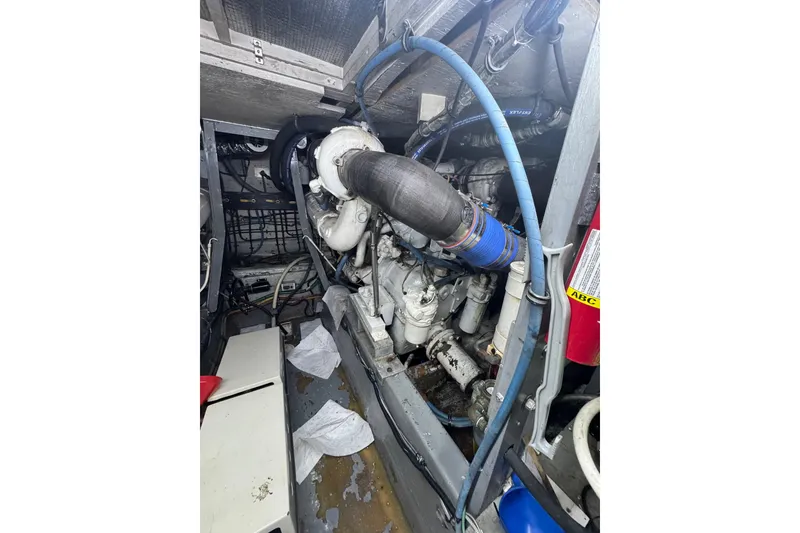 Slide: The Image of Engine room of a 1990 Hatteras 52 Convertible yacht, showcasing mechanical components. - 27