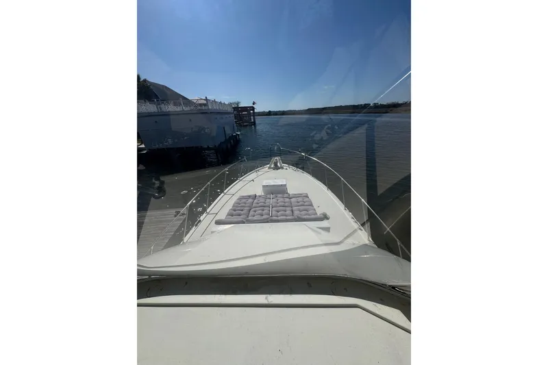Slide: The Image of 1990 Hatteras 52 Convertible yacht docked, view from bow with clear skies. - 3