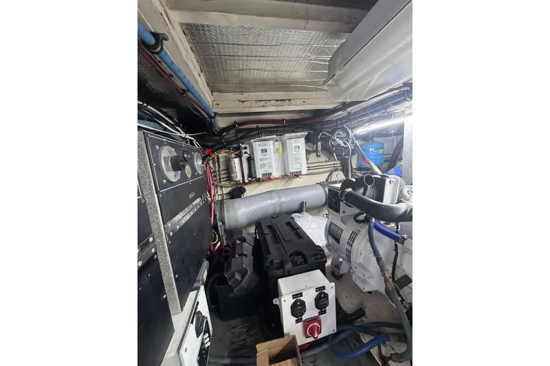 Slide: The Image of Engine room of a 1990 Hatteras 52 Convertible yacht, showcasing mechanical components. - 30