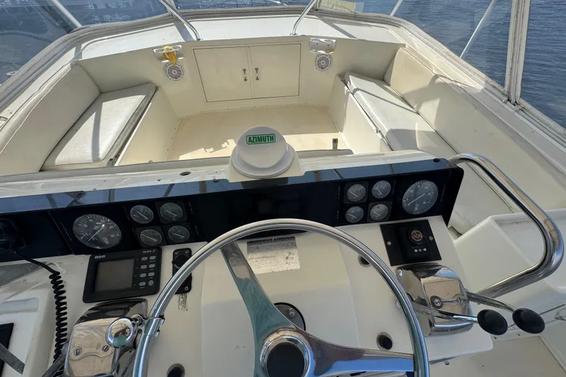 Slide: The Image of Cockpit view of 1990 Hatteras 52 Convertible yacht with steering wheel and navigation instruments. - 5