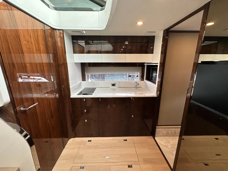 Slide: The Image of 2024 Fairline Targa 45 GT yacht kitchen with modern wood cabinetry and sleek design. - 23
