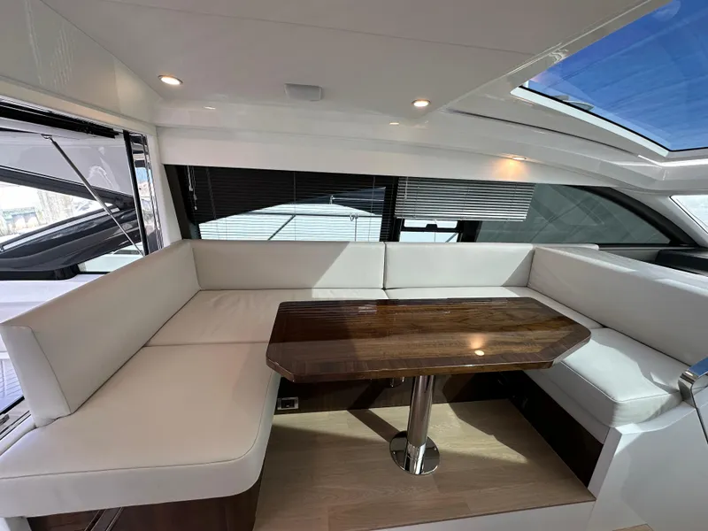 Slide: The Image of 2024 Fairline Targa 45 GT yacht interior with white seating and wooden table. - 31