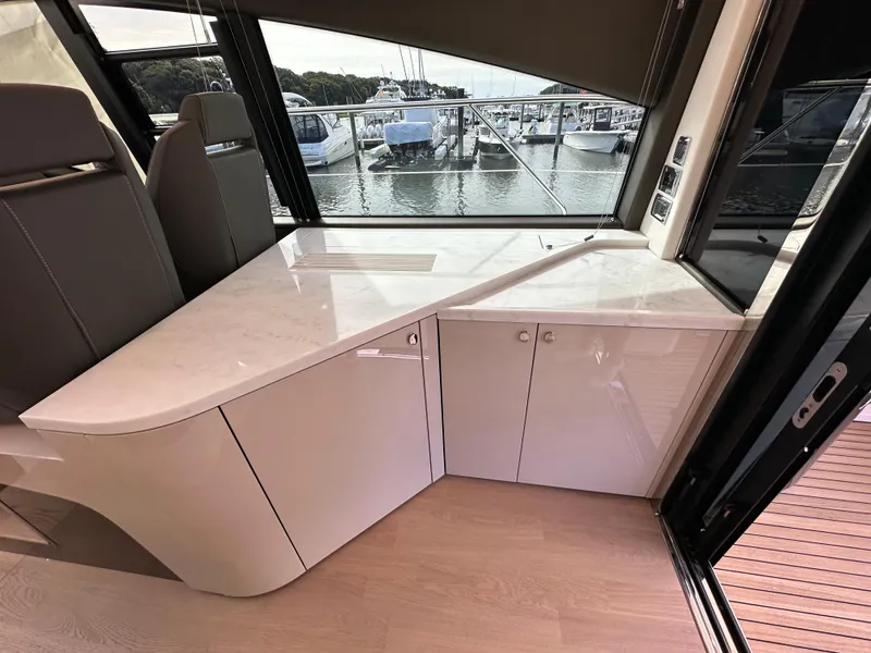 Slide: The Image of Interior of 2024 Fairline Targa 45 GT yacht with sleek white cabinetry and waterfront view. - 36