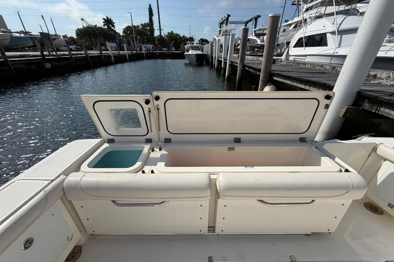 Slide: The Image of 2009 Pursuit OS 375 Offshore boat with open storage compartments at marina. - 12