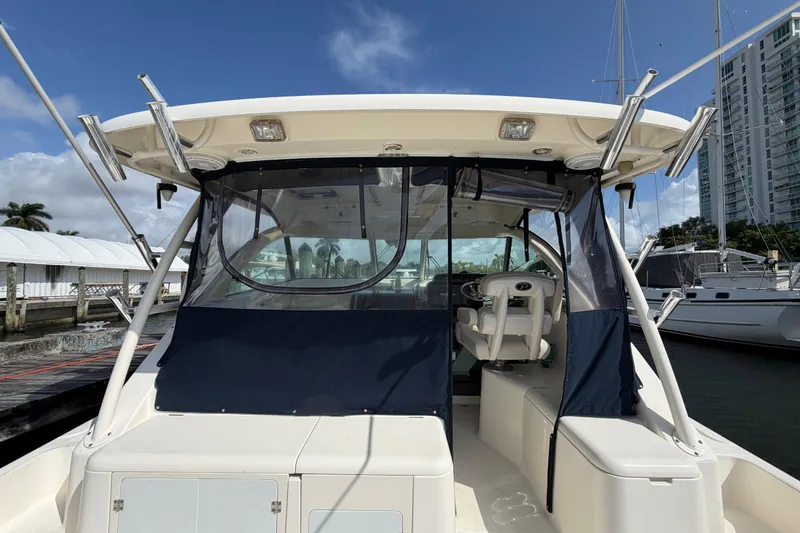 Slide: The Image of 2009 Pursuit OS 375 Offshore boat docked, featuring cockpit and seating area. - 13