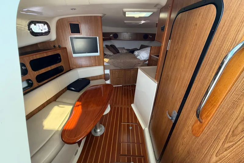 Slide: The Image of Interior of 2009 Pursuit OS 375 Offshore boat with wood accents and cozy seating area. - 16