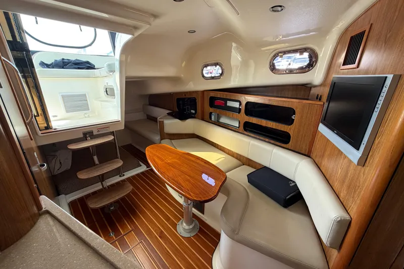 Slide: The Image of 2009 Pursuit OS 375 Offshore cabin interior with wood accents and seating area. - 18