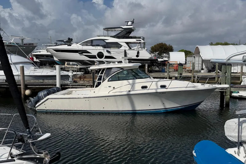 Slide: The Image of 2009 Pursuit OS 375 Offshore boat docked in a marina under cloudy skies. - 2