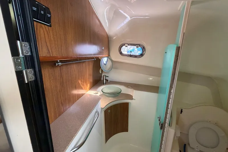Slide: The Image of 2009 Pursuit OS 375 Offshore boat bathroom with wood accents and modern fixtures. - 20