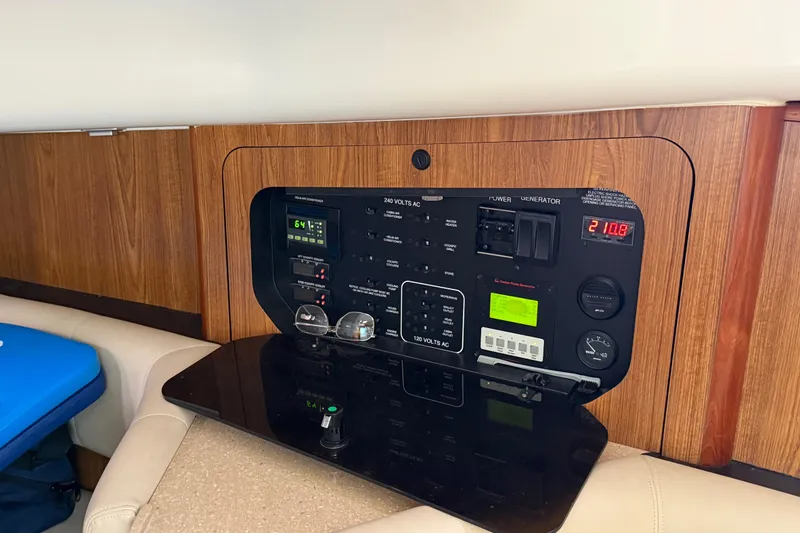 Slide: The Image of 2009 Pursuit OS 375 Offshore electrical panel with wood finish and control switches. - 24