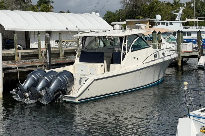 Slide: The Image of 2009 Pursuit OS 375 Offshore boat docked with triple Yamaha outboard engines. - 3