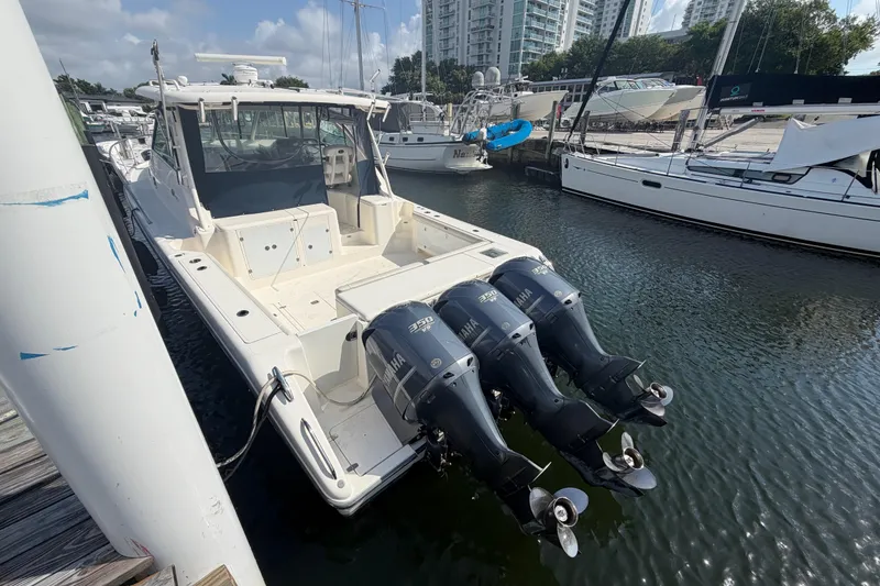 Slide: The Image of 2009 Pursuit OS 375 Offshore boat docked with triple Yamaha engines. - 4