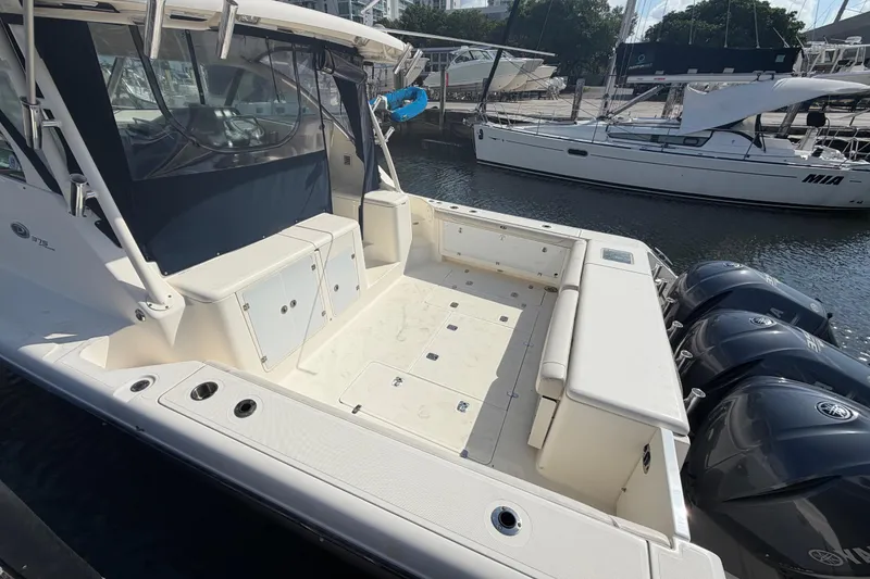 Slide: The Image of 2009 Pursuit OS 375 Offshore boat with triple outboard engines docked at marina. - 7