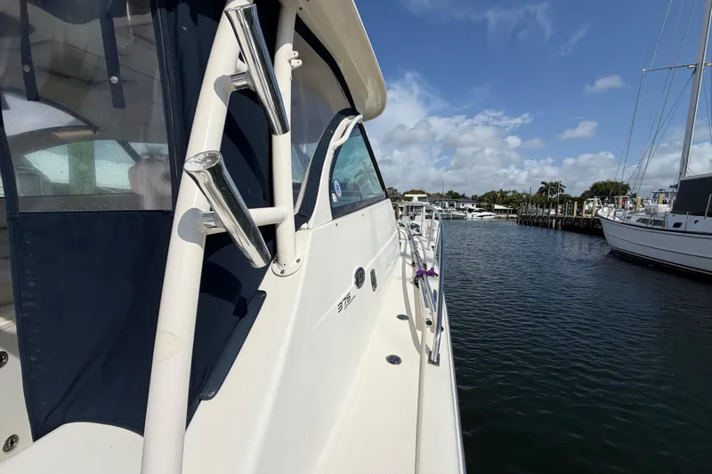 Slide: The Image of 2009 Pursuit OS 375 Offshore boat docked in a marina under a clear blue sky. - 8