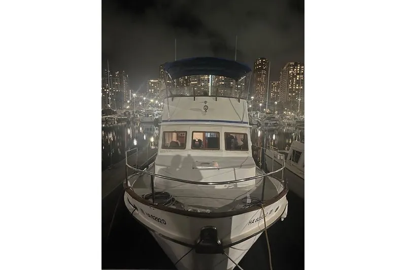 Slide: The Image of 1979 Cheoy Lee Sedan 35 yacht docked at night in a marina with city lights. - 12