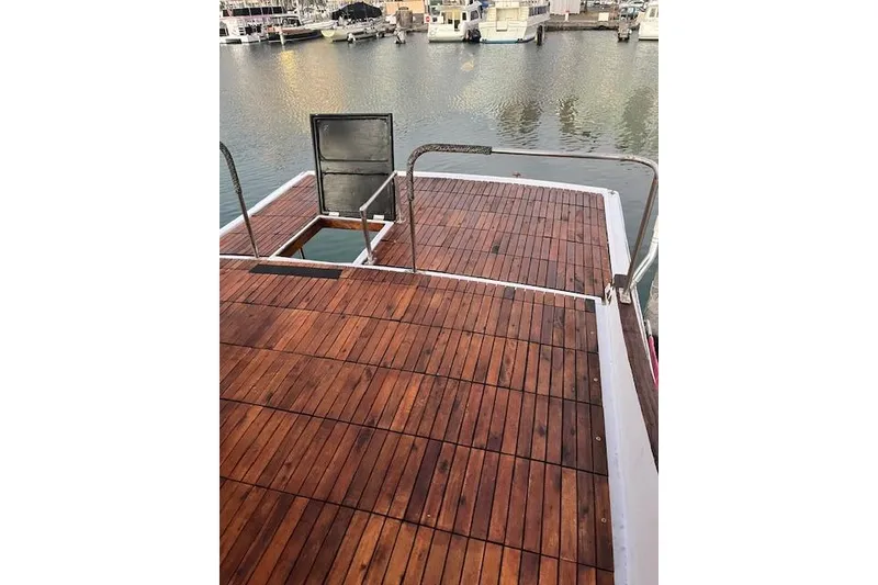 Slide: The Image of 1979 Cheoy Lee Sedan 35 boat deck with wooden finish, docked at marina. - 3