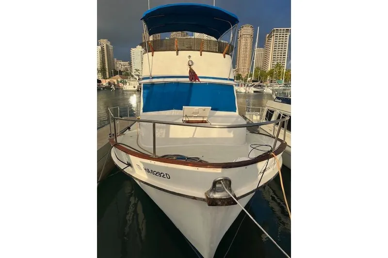 Slide: The Image of 1979 Cheoy Lee Sedan 35 yacht docked in a marina with city skyline backdrop. - 4