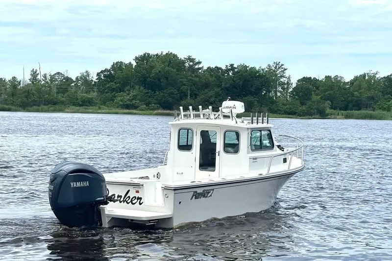 Slide: The Image of 2022 Parker 2320 Sport Cabin boat on a lake with Yamaha engine. - 3