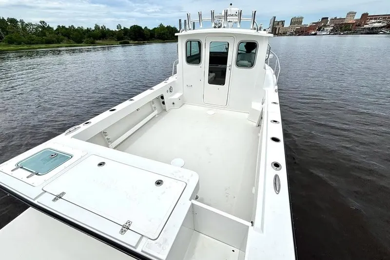 Slide: The Image of 2022 Parker 2320 Sport Cabin boat on calm river with cityscape background. - 8