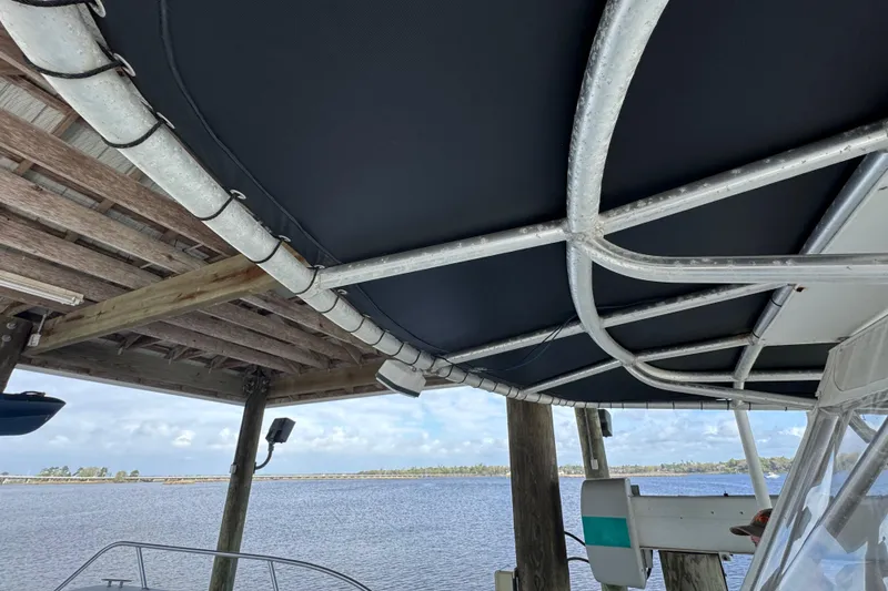 Slide: The Image of 2006 Twin Vee 36 Center Console boat under dock canopy, overlooking serene water. - 21