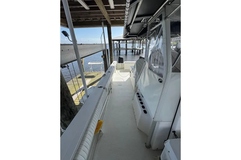 Slide: The Image of 2006 Twin Vee 36 Center Console boat docked, showcasing spacious deck and clear canopy. - 25