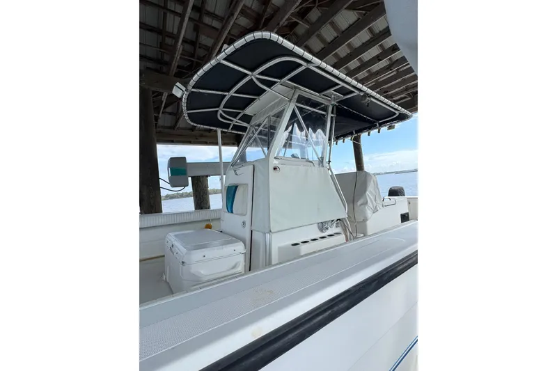 Slide: The Image of 2006 Twin Vee 36 Center Console boat under a dock, featuring a covered helm. - 4