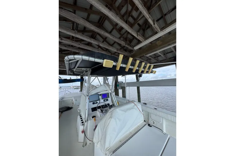 Slide: The Image of 2006 Twin Vee 36 Center Console boat under a wooden dock roof. - 6