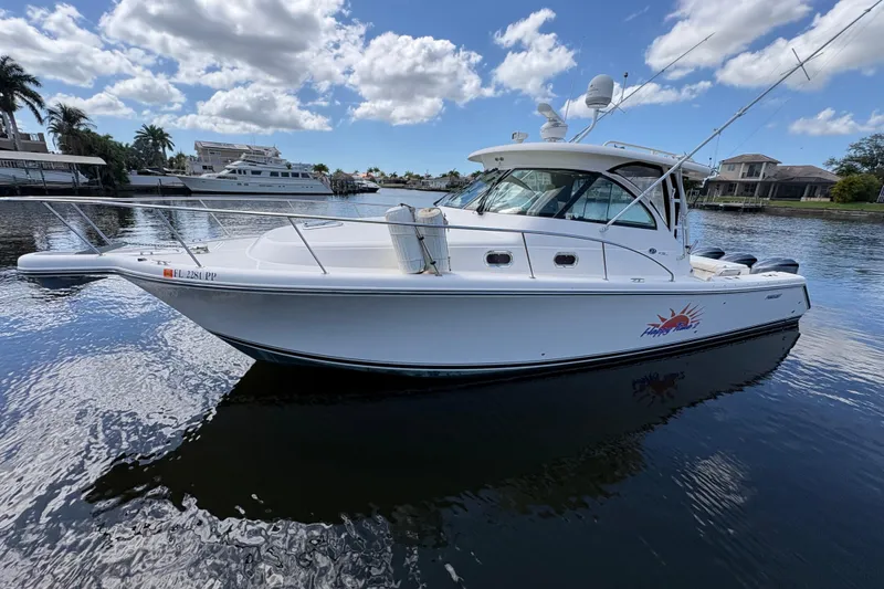 The Image of 2011 Pursuit OS 375 Offshore boat on calm water under a partly cloudy sky. - 0