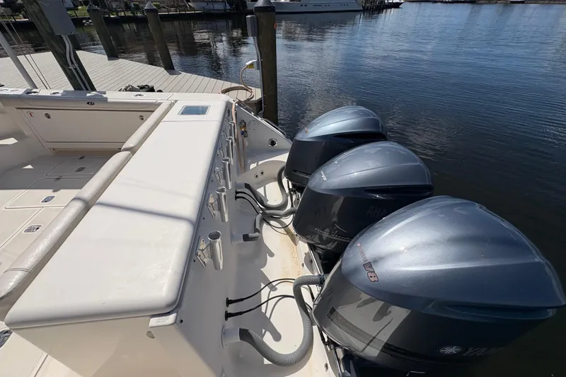 Slide: The Image of 2011 Pursuit OS 375 Offshore boat with triple Yamaha V8 engines docked by the water. - 10