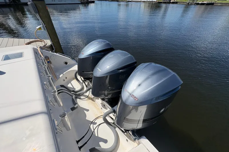 Slide: The Image of 2011 Pursuit OS 375 Offshore boat with triple Yamaha outboard engines docked by the water. - 11