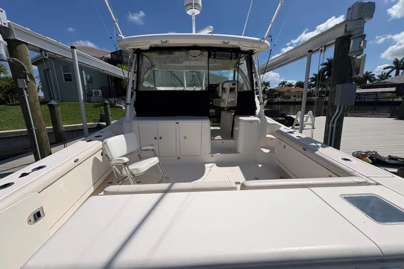 Slide: The Image of 2011 Pursuit OS 375 Offshore boat docked, showcasing spacious deck and seating area. - 15