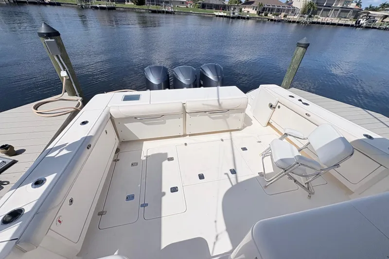 Slide: The Image of 2011 Pursuit OS 375 Offshore boat deck with seating and triple outboard motors. - 16
