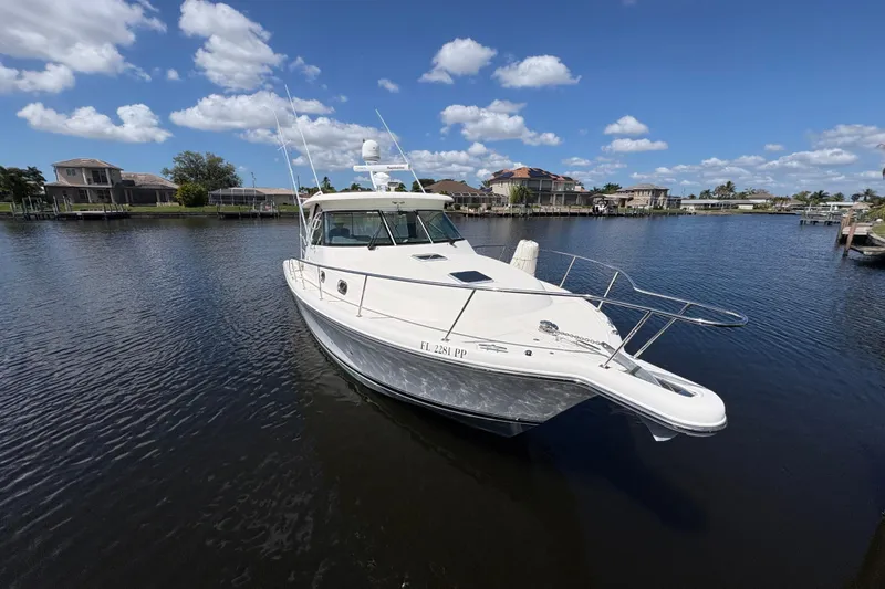 Slide: The Image of 2011 Pursuit OS 375 Offshore boat docked on a sunny day with blue skies. - 2