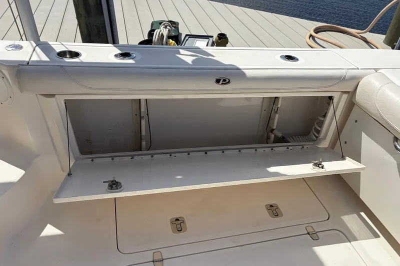 Slide: The Image of 2011 Pursuit OS 375 Offshore boat storage compartment open on deck. - 25