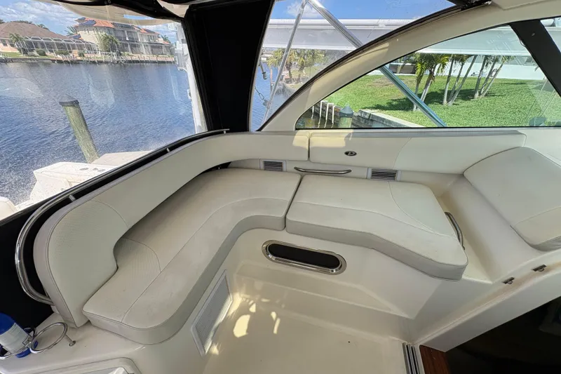Slide: The Image of 2011 Pursuit OS 375 Offshore boat interior with white seating and waterfront view. - 29